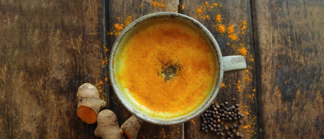 Flat lay shot of a turmeric latte on a wooden table